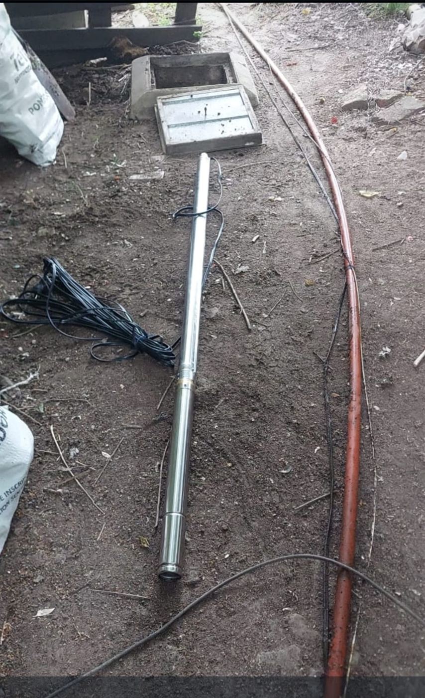 Bomba sumergible de acero inoxidable preparada junto a la boca del pozo